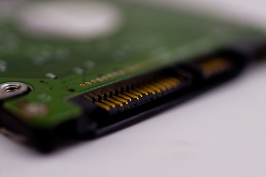 2.5mm laptop HDD on white blurred background. A lot of space on photo is defocused or have soft focus.