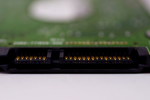 2.5mm laptop HDD on white blurred background. A lot of space on photo is defocused or have soft focus.