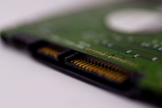 2.5mm laptop HDD on white blurred background. A lot of space on photo is defocused or have soft focus.