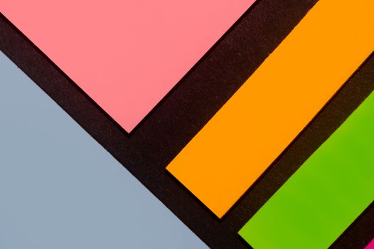 Blue, orange, green and rose hue colorful office stickers on black paper. Office noteparer as reminder. Isolated on black paper.