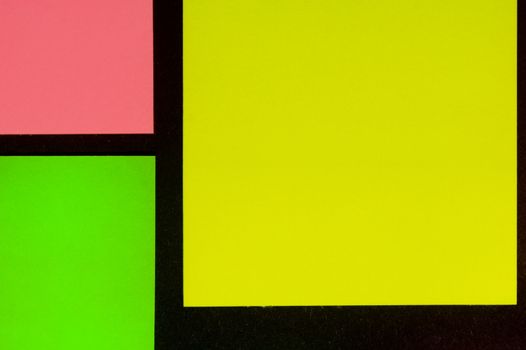 Green, yellow and rose hue colorful office stickers on black paper. Office noteparer as reminder. Isolated on black paper.
