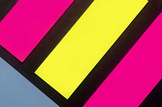 Blue, yellow and purple hue colorful office stickers on black paper. Office noteparer as reminder. Isolated on black paper.