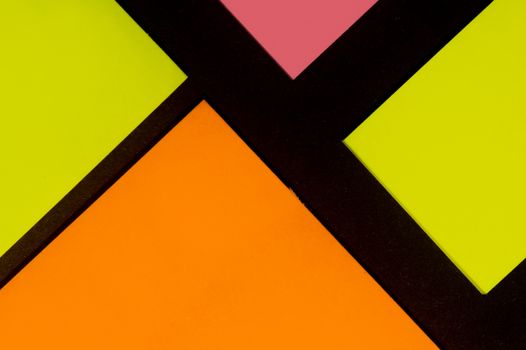 Yellow, orange and rose hue colorful office stickers on black paper. Office noteparer as reminder. Isolated on black paper.