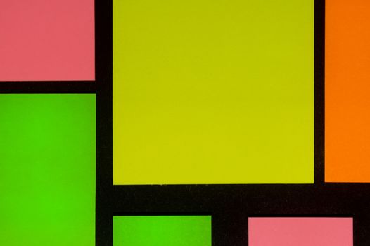 Green, yellow, orange and rose hue colorful office stickers on black paper. Office noteparer as reminder. Isolated on black paper.