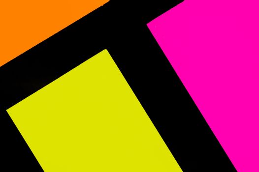 Yellow, orange and purple hue colorful office stickers on black paper. Office noteparer as reminder. Isolated on black paper.