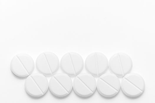 White pills on white background. Close-up view. Medical background. Healthcare image.