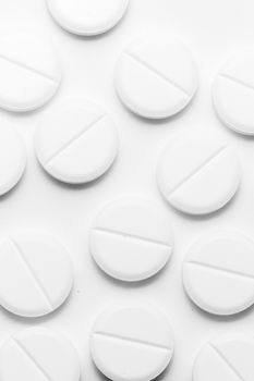 White pills on white background. Close-up view. Medical background. Healthcare image.