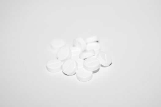 White pills on white background. Close-up view. Medical background. Healthcare image.