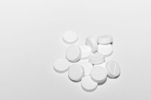 White pills on white background. Close-up view. Medical background. Healthcare image.