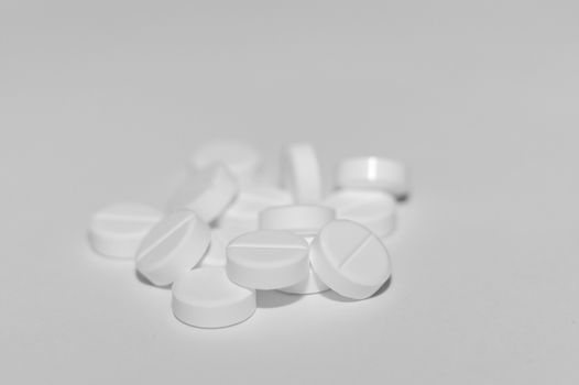 White pills on white background. Close-up view. Medical background. Healthcare image.