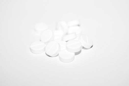 White pills on white background. Close-up view. Medical background. Healthcare image.