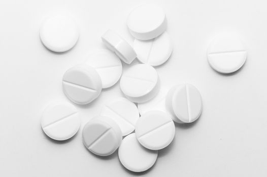 White pills on white background. Close-up view. Medical background. Healthcare image.