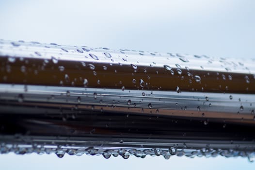 Chrome steel pipes with water drops in river port after rain.