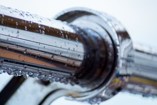 Chrome steel pipes with water drops in river port after rain.