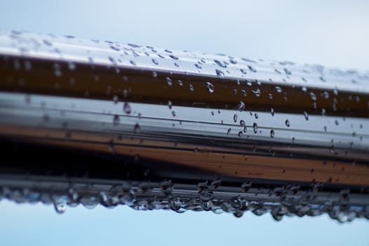 Chrome steel pipes with water drops in river port after rain.