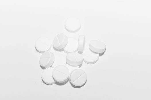 White pills on white background. Close-up view. Medical background. Healthcare image.