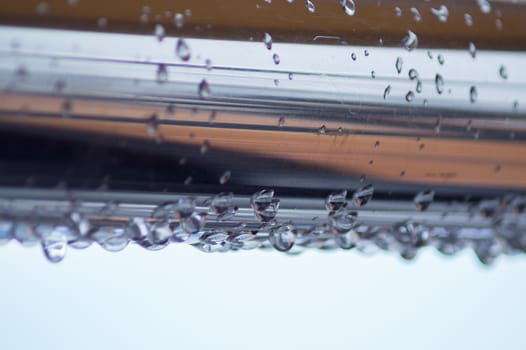 Chrome steel pipes with water drops in river port after rain.