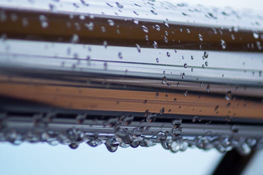 Chrome steel pipes with water drops in river port after rain.