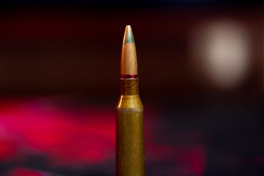 Rifle AK-47 ammo bullet close-up on blurred background. Armor piercing cartridge.