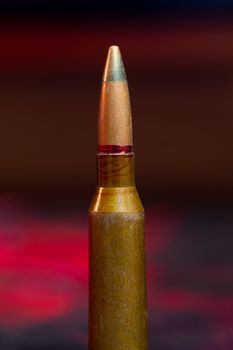 Rifle AK-47 ammo bullet close-up on blurred background. Armor piercing cartridge.