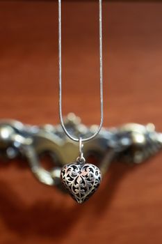 Close up photo of female neck silver pendand on blurred background. A handwork sterling silver pendant look as heart. Macrophoto with blurred background.