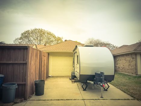 Rear view of RV trailer parked at house garage backyard