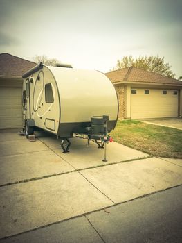 Rear view of RV trailer parked at house garage backyard