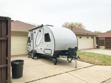 Rear view of RV trailer parked at house garage backyard