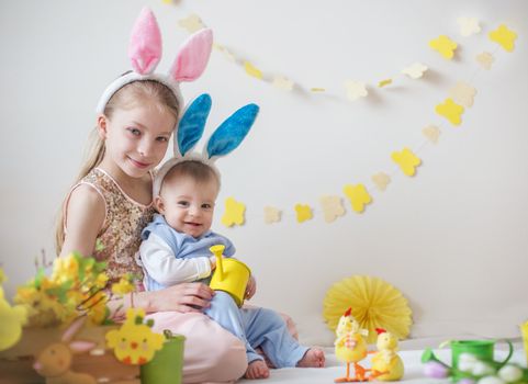 Two cute little children boy and girl wearing bunny ears in Easter decor