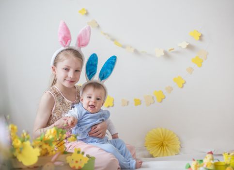 Two cute little children boy and girl wearing bunny ears in Easter decor