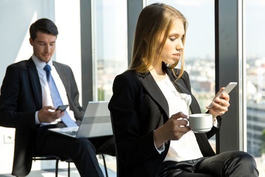 Young workers having break at office and resting near window