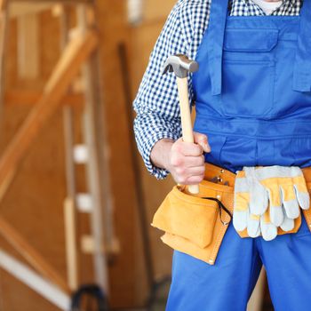 Construction worker at construction site holding hammer