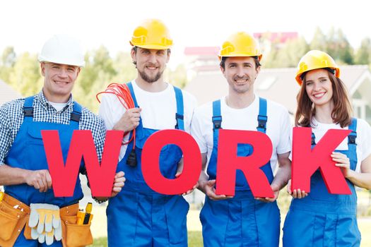 Happy workers in uniform holding work letters