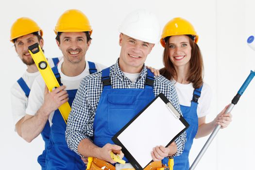 Team of happy smiling workers with tools and contract