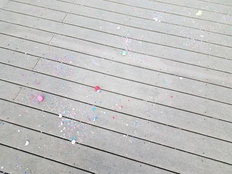 colorful cracked egg shells and paper confetti on wood deck