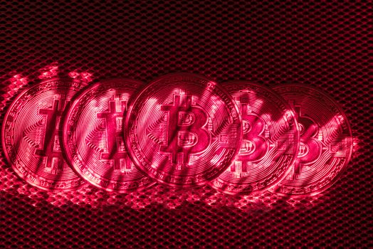 Top view of golden bit coins painted with red laser light.Bit coin digital currency and coin money stack on silver metallic dark background and surface
