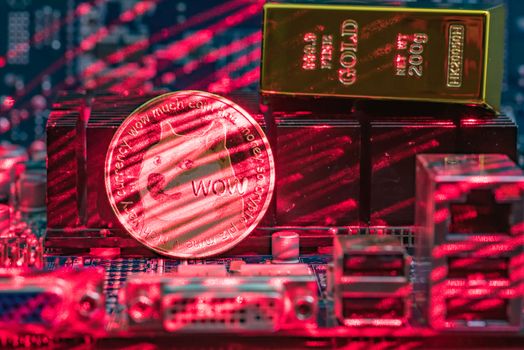 Front view of Dogecoin cryptocurrency and golden brick or block painted with red laser stands on computer video card.Bitcoin mining farm concept.