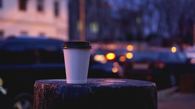 Take away coffee cup empty blank copy space for your design text or banner of brand, hot drink on wood table with beautiful city light decoration