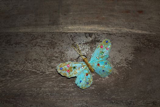 Dreamy turquoise beautiful butterfly on brown rustic wood background