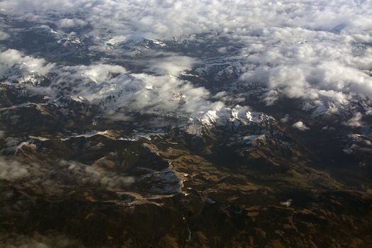 Swiss Alpes with snowy mountain tops aerial view towards the east during afternoon flight in December