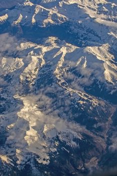 Swiss Alpes with snowy mountain tops aerial view towards the east during afternoon flight in December