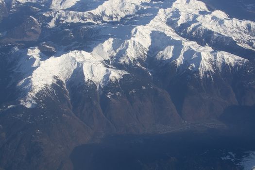 Swiss Alpes with snowy mountain tops aerial view towards the east during afternoon flight in December