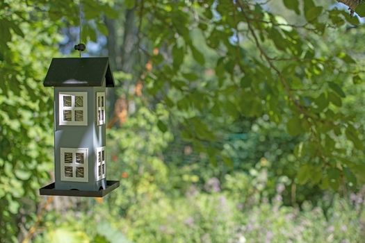 Cute birdhouse hanging in green garden concept for buying or selling real estate new home or starting a family
