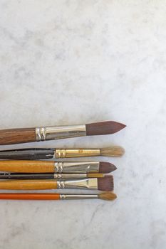 Set of various artist brushes for watercolor painting on old shabby grungy retro vintage wooden background.