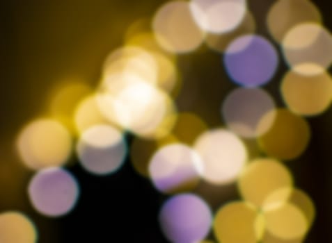 Bokeh lights defocussed festive winter background texture gold and purple colors