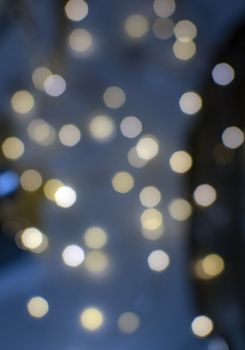 Bokeh lights defocussed festive winter background texture in blue color.