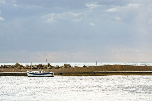 Mediterranean sea view with pier against dark skies with dramatic light