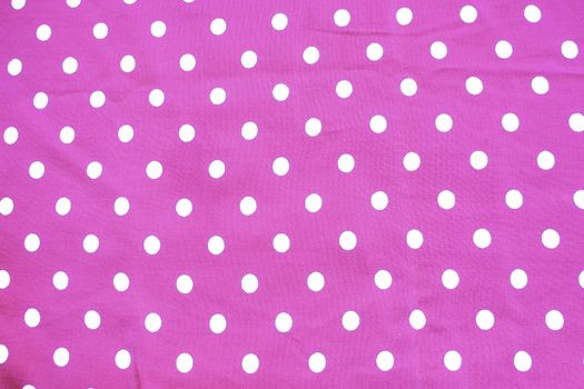 Pink and white polka dot printed fabric fun romantic background texture.