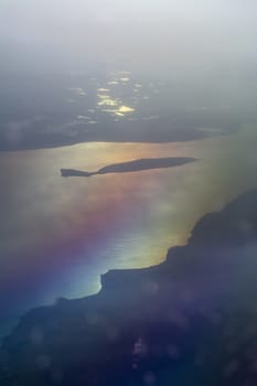 Aerial landscape with golden light over Lake Vattern with Visingso tainted in rainbow colors in Sweden