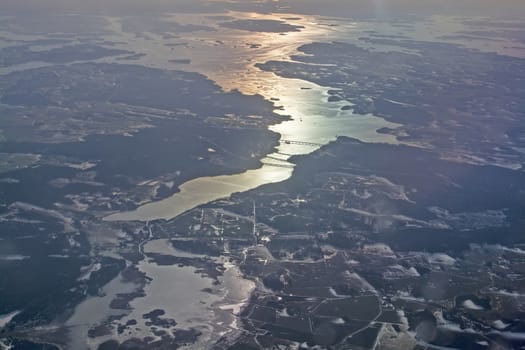 Aerial landscape with golden light over water and forest in Sweden